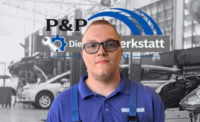 Kfz-Mechatroniker in blauer Arbeitskleidung vor Werkstattlogo in Delmenhorst