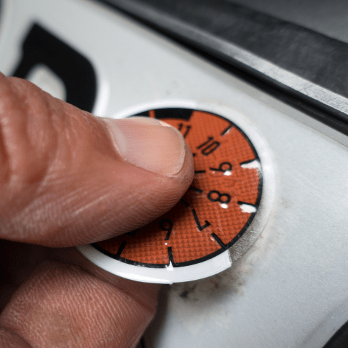 HU-Plakette wird auf Kfz-Kennzeichen bei Autowerkstatt Delmenhorst angebracht