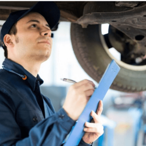 Mechaniker mit Klemmbrett prüft Auto während Inspektion in Autowerkstatt Delmenhorst