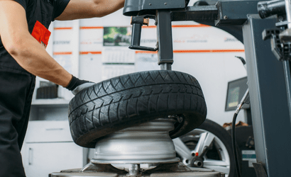 Reifenservice Kfz-Werkstatt Delmenhorst: Monteur wechselt Autoreifen mit Spezialgerät